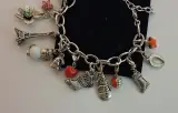 Zilverkleurige bedelarmband met diverse bedels – foto 2 – kavel bij De Kringwinkel, Aalst