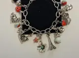 Zilverkleurige bedelarmband met diverse bedels – foto 3 – kavel bij De Kringwinkel, Aalst