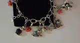 Zilverkleurige bedelarmband met diverse bedels – foto 4 – kavel bij De Kringwinkel, Aalst