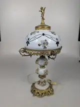 Decoratieve vintage tafellamp met porseleinen kap, bloemenmotief en rijkelijke messingdecoratie – kavel bij De Kringwinkel, Sint-Niklaas