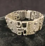 Zilverkleurige armband met reliëf en veiligheidssluiting – kavel bij De Kringwinkel, Turnhout