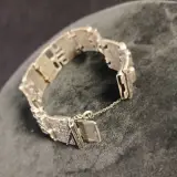 Zilverkleurige armband met reliëf en veiligheidssluiting – foto 4 – kavel bij De Kringwinkel, Turnhout