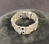 Zilverkleurige armband met reliëf en veiligheidssluiting – foto 5 – kavel bij De Kringwinkel, Turnhout