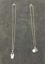 Set van twee zilveren kettingen met hangers – kavel bij De Kringwinkel, Turnhout
