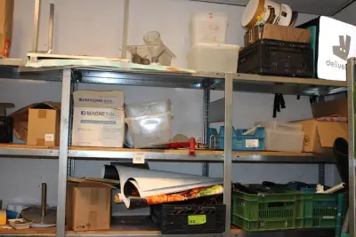 Inhoud van vier stellingdelen waaronder werkschoenen, schorten, tissuedispenser, kunststoffen bakken en stickerrollen – kavel bij HNVI, Eindhoven