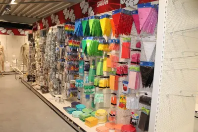 Feestartikelen/accessoires aan vier en halve wandschap w.o. ballonnen, slingers, kaarsen, buttons en tasjes, bordjes en bestek – kavel bij HNVI, Oirschot