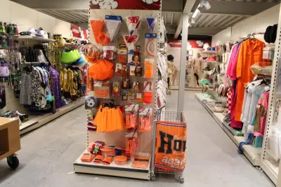 Oranje producten op kopstelling en in winkelmand w.o. vlaggen, caps, mutsen, toeters, servies en brillen – kavel bij HNVI, Oirschot