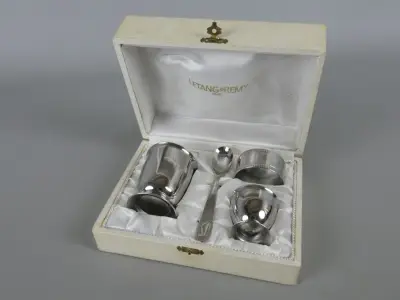 Set zilverkleurige eierdop, beker, lepel en servetring in doos – kavel bij De Kringwinkel, Diest