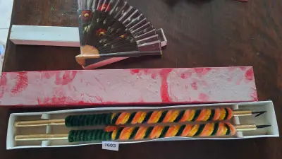 Decoratieve set bestaande uit twee ceremoniële speren met gekleurde handvaten en een handwaaier in originele doosjes – kavel bij Goeiendeal, Houthalen-Helchteren