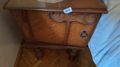 Klassiek nachtkastje met een glazen top en een klapdeur met sierlijk snijwerk – kavel bij Goeiendeal, Houthalen-Helchteren