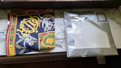 Zijden sjaal met engelenmotief samen met een zilverkleurige verpakking – kavel bij Goeiendeal, Houthalen-Helchteren