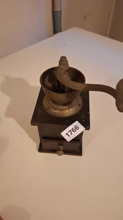 Klassieke koffiemolen met een metalen trechter en een draaihendel op een donkere voet – kavel bij Goeiendeal, Houthalen-Helchteren