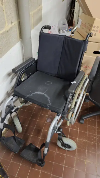 Opvouwbare handbewogen rolstoel met zwarte bekleding en grijze voetsteunen – kavel bij Goeiendeal, Houthalen-Helchteren