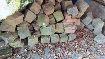 Partij gebruikte kasseien / straatstenen opgestapeld op de grond – kavel bij Goeiendeal, Houthalen-Helchteren