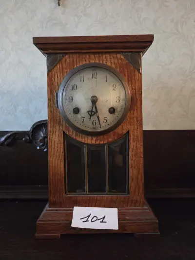 Klassieke schouwklok met een rechthoekige houten kast, ronde wijzerplaat en glas-in-lood venster onderaan – Lot 101 – kavel bij Goeiendeal, Jette