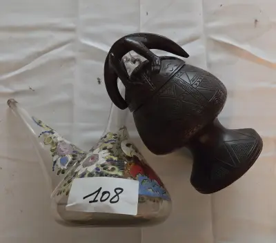 Kavel bestaande uit een gedecoreerde porron (Spaanse schenkkan) en een donkere vaas/bokaal met geometrisch motief en figuur op het deksel – Lot 108 – kavel bij Goeiendeal, Jette