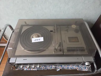 Vintage Philips audio-installatie met een geïntegreerde platenspeler en cassettedeck onder een kunststof stofkap – Lot 111 – kavel bij Goeiendeal, Jette