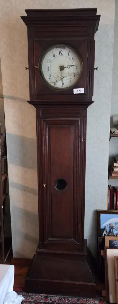 Klassieke staande klok / lantaarnklok in een hoge houten kast met barsten in de ronde wijzerplaat – Lot 112 – kavel bij Goeiendeal, Jette