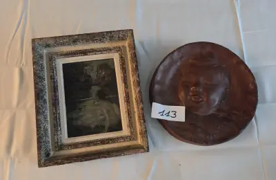 Set bestaande uit een klein ingelijst schilderij van een figuur bij het water en een rond reliëfportret van een kind – Lot 113 – kavel bij Goeiendeal, Jette