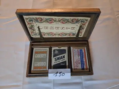 Houten speelkaartendoos met gedecoreerde binnenzijde, gevuld met drie kaartspellen waaronder Swan 501, CGER en Rega Radio 400 – Lot 150 – kavel bij Goeiendeal, Jette