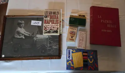 Set met diverse verzamelobjecten, waaronder een ingelijste zwart-wit foto van een kind in een trapauto, boeken zoals La Patrie Belge en kleurpotlod… – kavel bij Goeiendeal, Jette