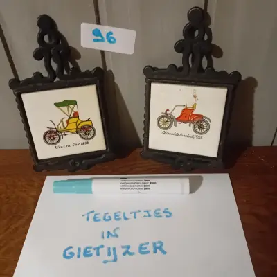 2 stuks decoratieve tegeltjes met afbeeldingen van klassieke voertuigen (Winton Car 1898 en Oldsmobile Runabout 1901) in een sierlijk frame (Lot: 96) – kavel bij Goeiendeal, Lommel