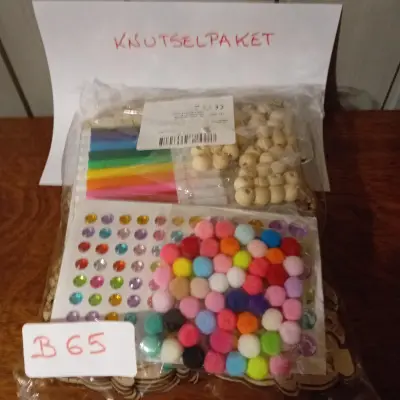 Knutselpakket met diverse hobbymaterialen waaronder pompons, strassteentjes en gekleurde sticks, nieuw in verpakking (Lot: B 65) – kavel bij Goeiendeal, Lommel