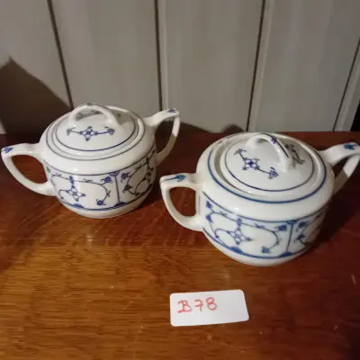 2 stuks suikerpotten met bijbehorende deksels, wit met een blauw geometrisch en floraal randmotief (Lot: B 78) – kavel bij Goeiendeal, Lommel
