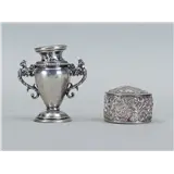 Een lot zilver bestaande uit een rijkbewerkt pillendoosje en een miniatuur vaas, gemerkt 800 en Minerva – kavel bij Medusa Auctioneers
