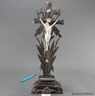 Antiek staand houten kruisbeeld te zijn (een zogeheten Arma Christi of Passiekruis) uit de late 19e of vroege 20e eeuw. Met zilvertinnen corpus – kavel bij ProVeiling, Wageningen