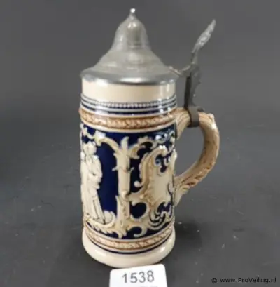 Vintage Duitse keramische bierpul met kobaltblauw reliëf en een tinnen deksel – kavel bij ProVeiling