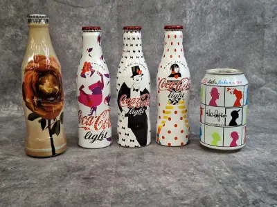 Set van 5 Coca-Cola Limited Fashion Edition Flessen & Blik - Marc Jacobs, Elvis Pompilio & Vintage Rose – kavel bij De Kringwinkel, Gent