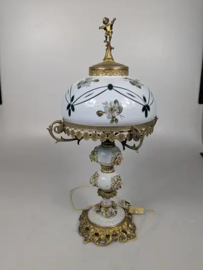 Decoratieve vintage tafellamp met porseleinen kap, bloemenmotief en rijkelijke messingdecoratie – kavel bij De Kringwinkel, Sint-Niklaas