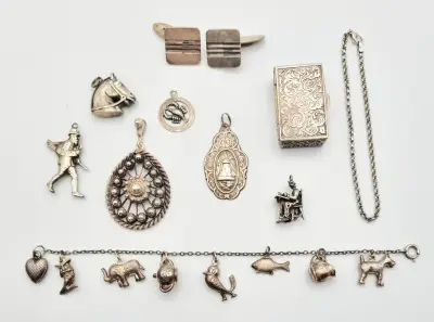 Convoluut zilveren sieraden – hangers, bedelarmband, manchetknopen en doosje, 20e eeuw – kavel bij Veilinghuis Klinkhamer, Groningen