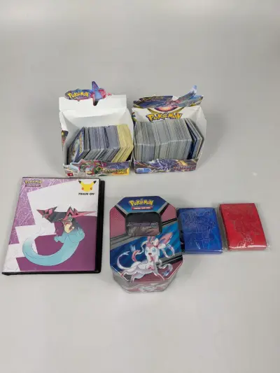 Pokémon verzamel collectie met kaarten, tin, kaarthoezen en map – kavel bij De Kringwinkel, Sint-Niklaas