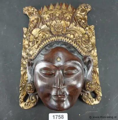 Handgesneden Balinees wandmasker van de rijstgodin Dewi Sri, prachtig gekenmerkt door de gedetailleerde, goudkleurige houtsnijwerken op de kroon – kavel bij ProVeiling