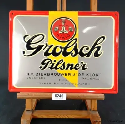 Metalen reclamebord van Grolsch Pilsner met de historische vermelding van bierbrouwerij De Klok – kavel bij ProVeiling, Wageningen