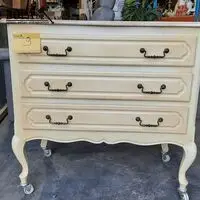 Vintage cremekleurige kast met donkerblauwe lades en sierlij – kavel bij BOPA Auctions, Aarsele