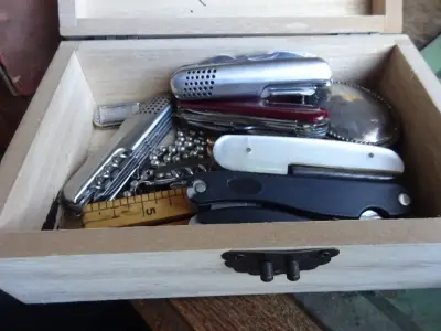Doos met enkele juwelen, zakmessen, mondharmonica – kavel bij Openbare Verkopen, Izegem