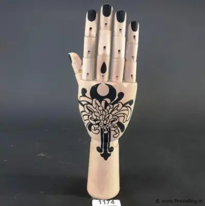 Gearticuleerde/gelede houten hand met een decoratieve, met de hand aangebrachte tatoeage-achtige illustratie van een chrysant op de handpalm en zwa… – kavel bij ProVeiling, Nederla